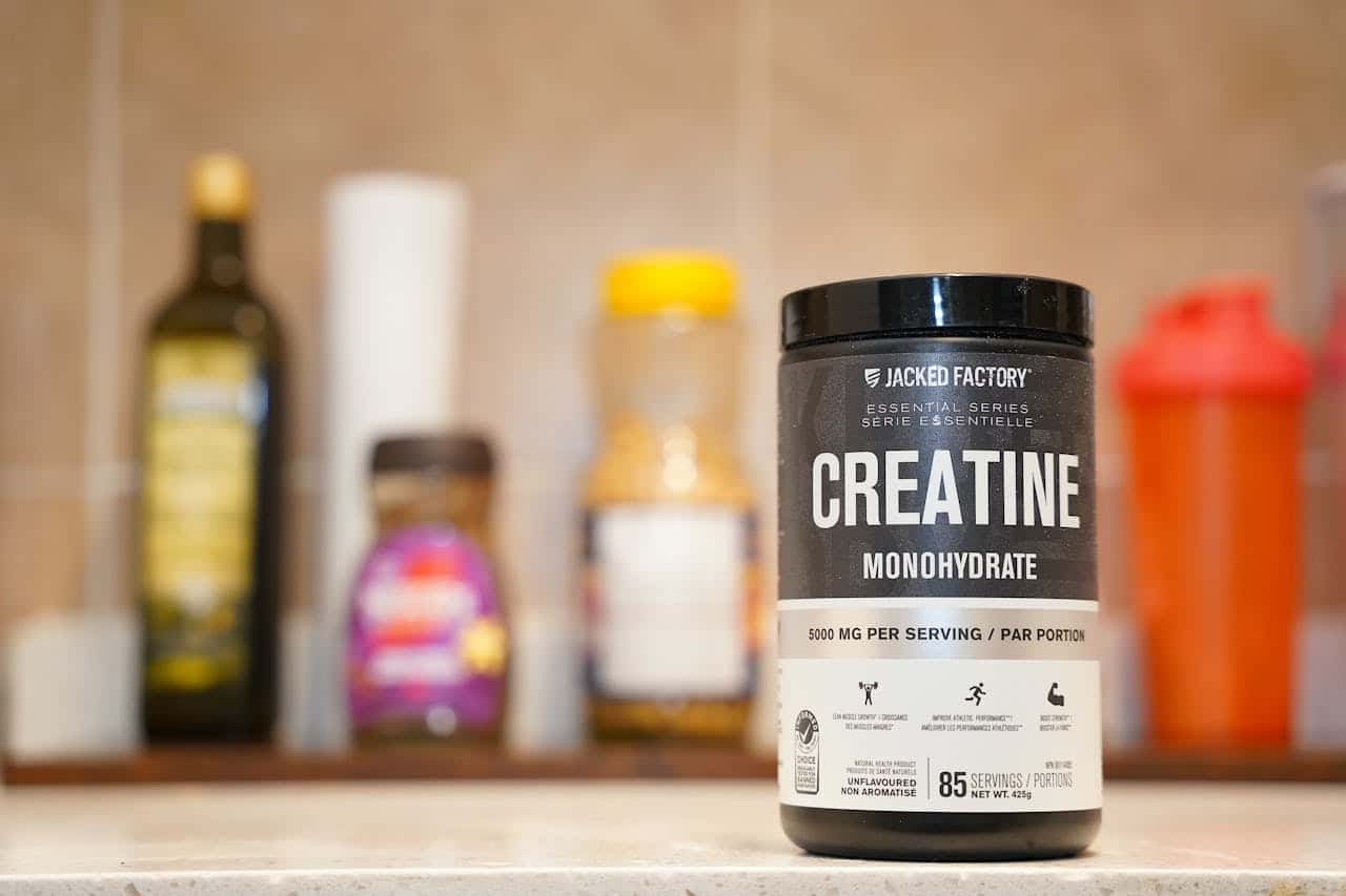 Produtos Creatine monohydrate from Jacked Factory displayed on a kitchen counter.
